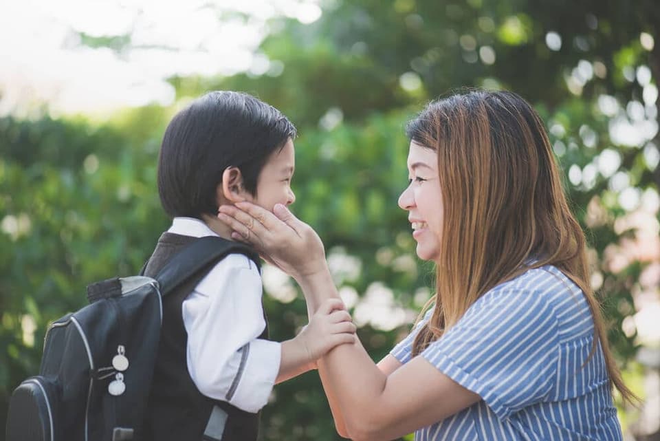 แม่ส่งลูกชายไปโรงเรียนอย่างมีความสุข